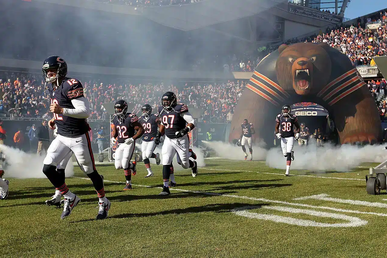 Chicago Bears players run onto the field through smoke before a game at Soldier Field in Chicago.