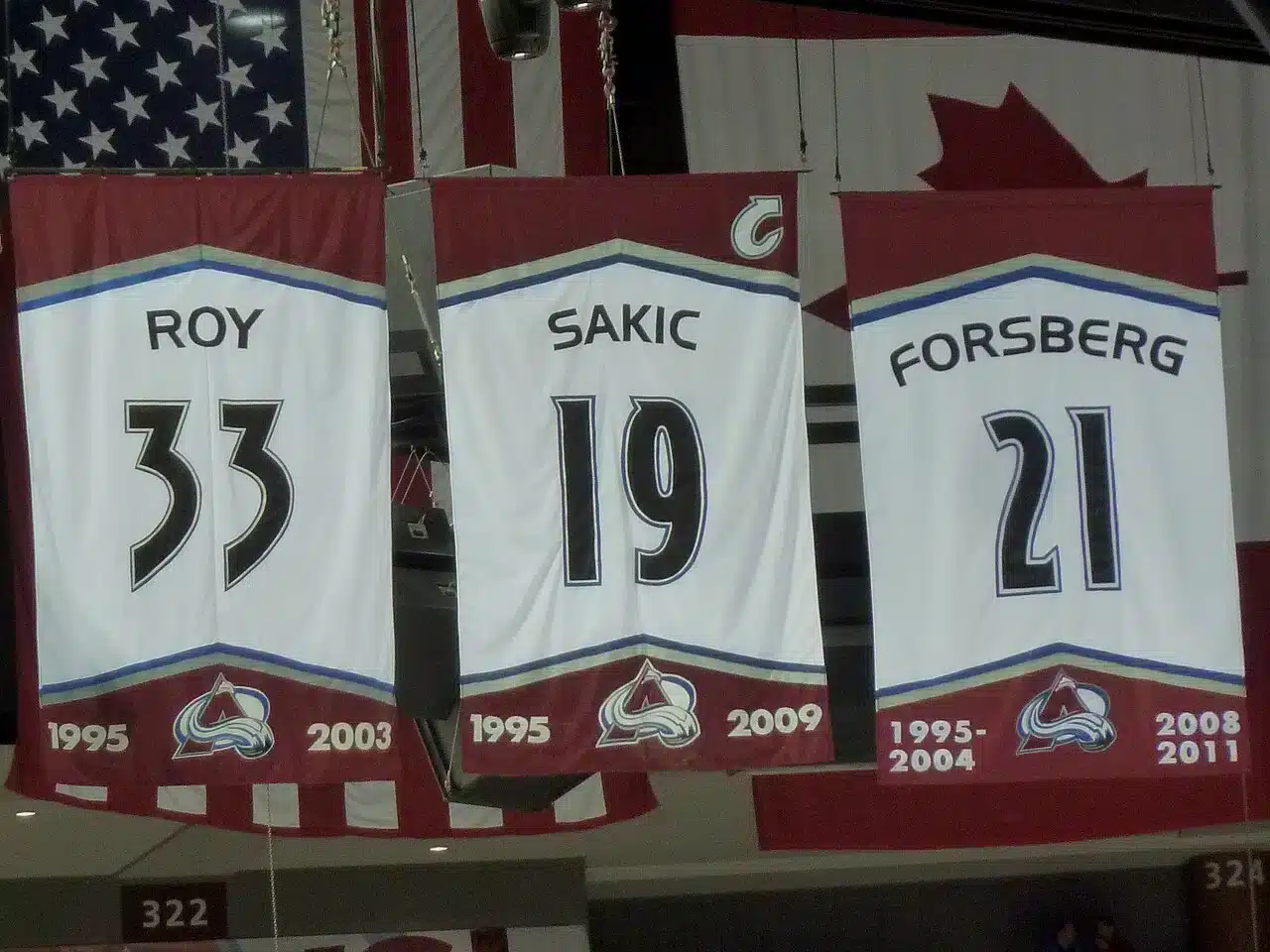 Colorado Avalanche retired jersey banners for Roy 33, Sakic 19 and Forsberg 21 hanging from the arena rafters, a reminder of the standard amid the Colorado Avalanche struggles.